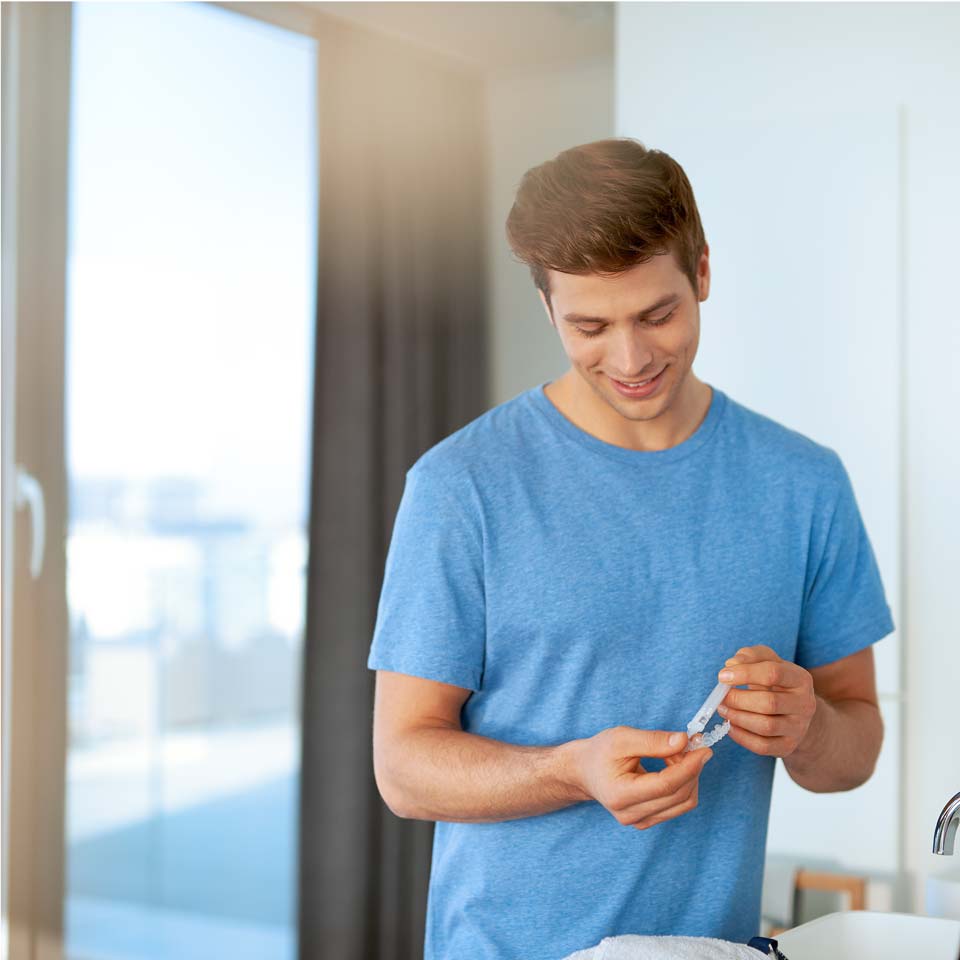 Man applying whitening gel to a custom tray