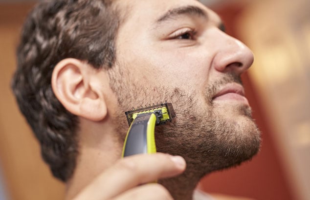 A man is trimming his short chin beard