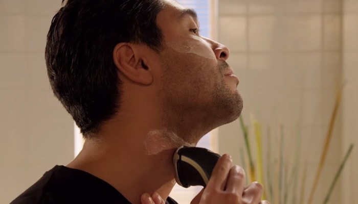 Man shaving his beard neckline to create a stubble beard